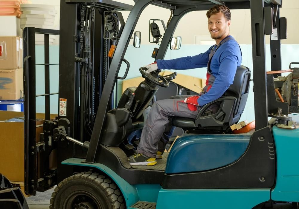 Man is Sitting in a Forklift in a Warehouse — Bundaberg Forklift Repairs Maryborough, QLD