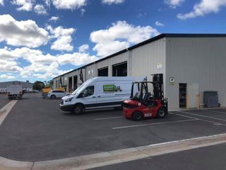 White Van and a Red Forklift Are Parked in Front of a Building — Bundaberg Forklift Repairs Bundaberg North, QLD