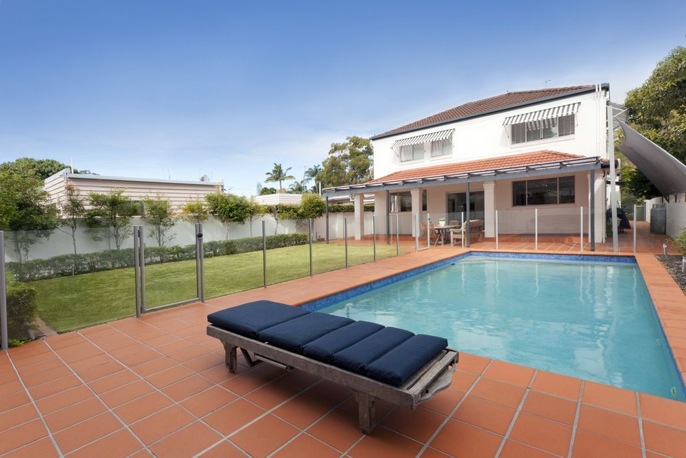 There is a large swimming pool in the backyard of a house — Mid Coast Glass Fencing In Port Macquarie, NSW