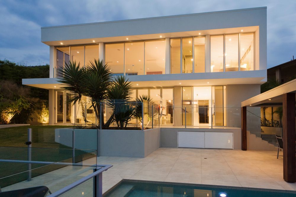A modern house with a swimming pool in front of it — Mid Coast Glass Fencing In Wauchope, NSW