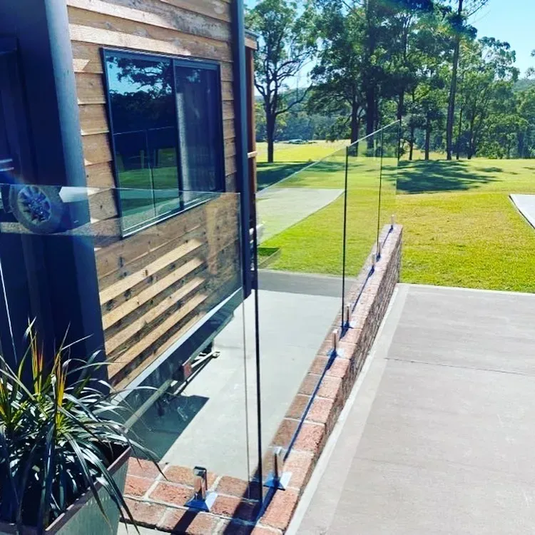 A house with a brick wall and a glass railing — Mid Coast Glass Fencing In Old Bar, NSW