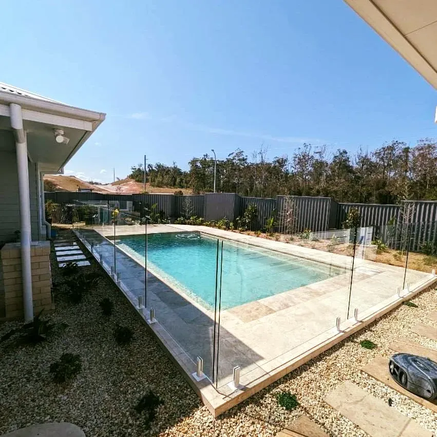 There is a large swimming pool in the backyard of a house — Mid Coast Glass Fencing In Bonny Hills, NSW