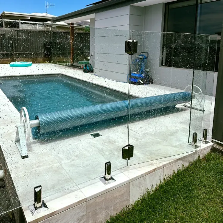 A large swimming pool with a glass fence around it — Mid Coast Glass Fencing In Bonny Hills, NSW