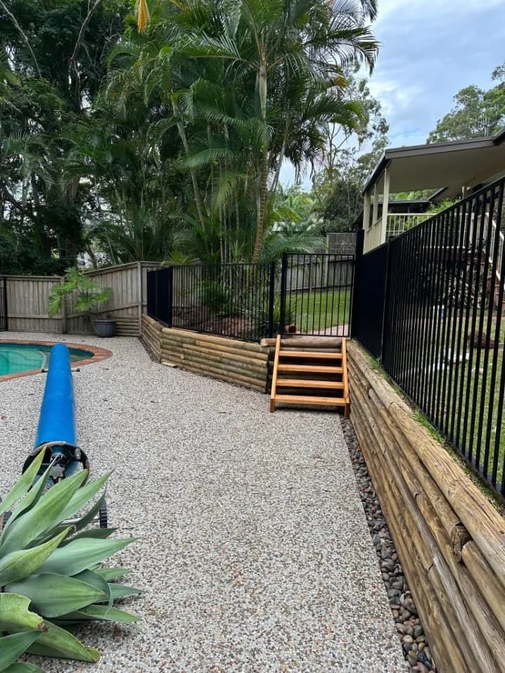 A Wooden Walkway Leading To A Swimming Pool Next To A FeNCE — Mid Coast Glass Fencing In Port Macquarie, NSW