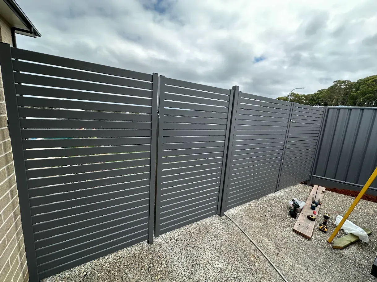 A fence is being built in the backyard of a house — Mid Coast Glass Fencing In Forster, NSW