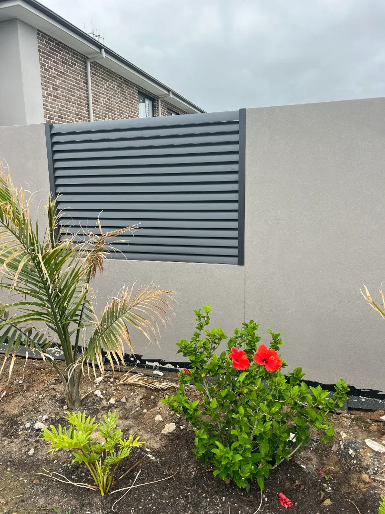 A garden with a fence and flowers in front of a house — Mid Coast Glass Fencing In Forster, NSW