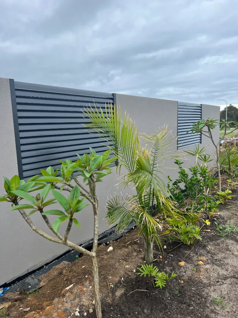 A Fence With A Few Trees In Front Of IT — Mid Coast Glass Fencing In Taree, NSW