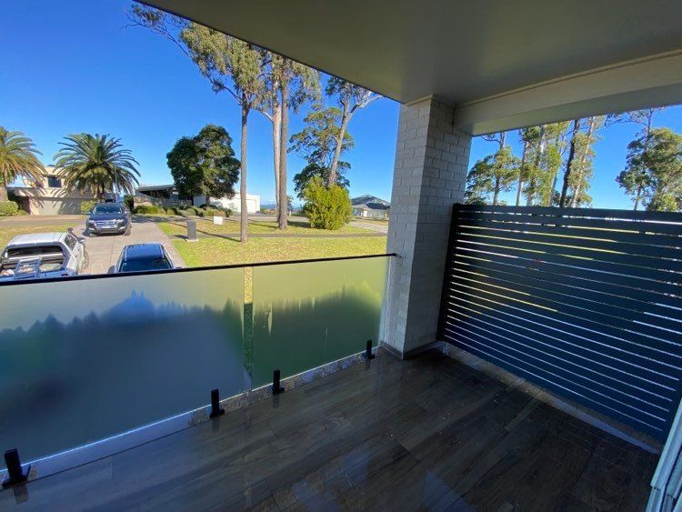 A balcony with a fence and a view of a residential area — Mid Coast Glass Fencing In Old Bar, NSW