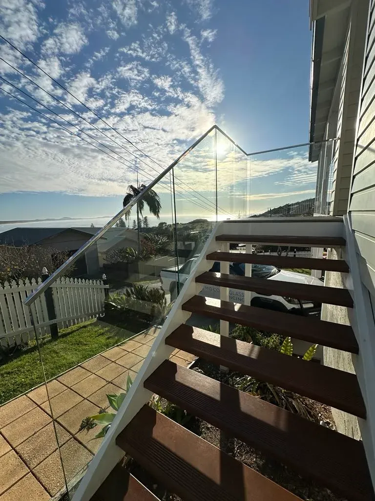 A Set Of Stairs Leading Up To A Balcony With A Glass RailING — Mid Coast Glass Fencing In Taree, NSW
