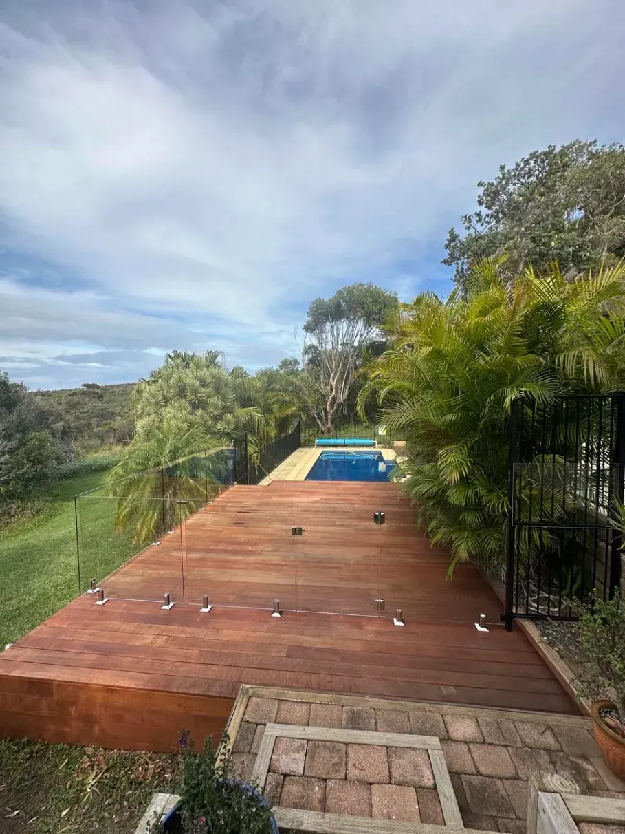 A Large Wooden Deck With A Swimming Pool In The BackgroUND — Mid Coast Glass Fencing In Laurieton, NSW