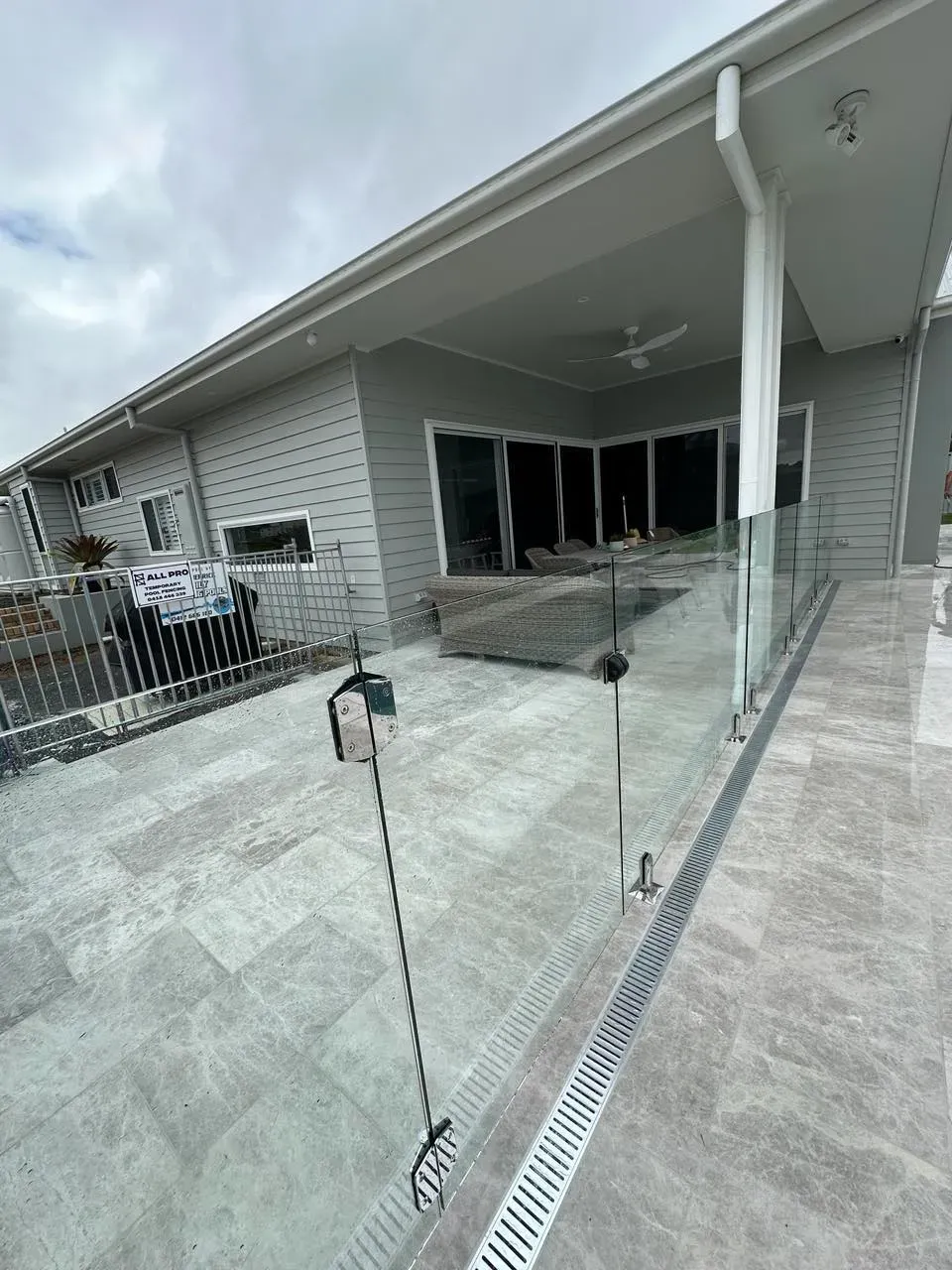 A large house with a patio and a glass railing — Mid Coast Glass Fencing In Forster, NSW