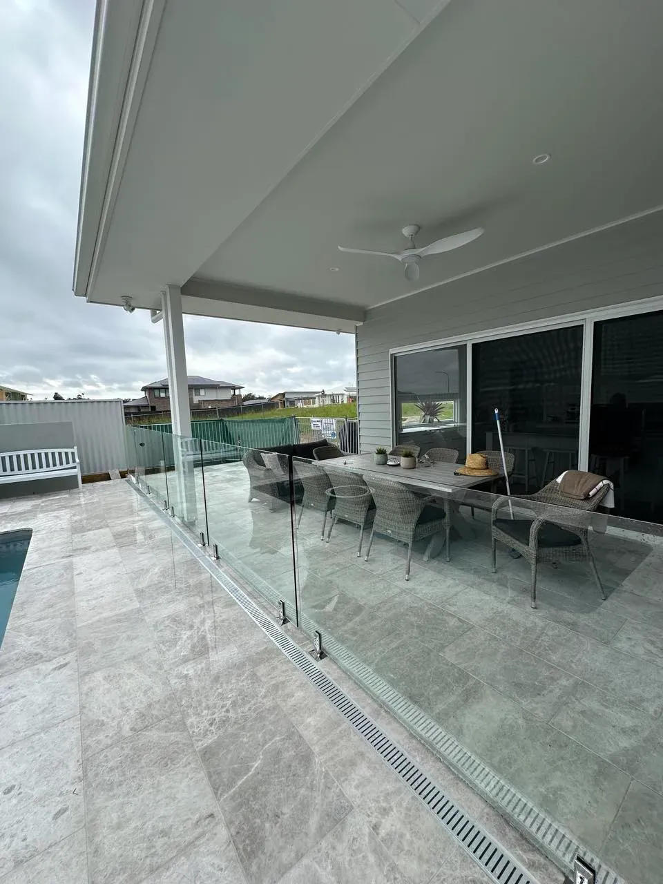 A Patio With A Glass Railing And A Swimming Pool In The BackgroUND — Mid Coast Glass Fencing In Taree, NSW