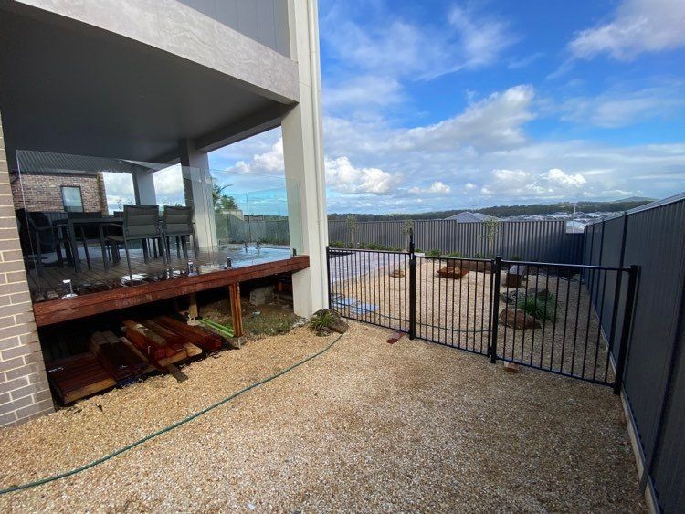 There is a fence in the backyard of a house — Mid Coast Glass Fencing In Old Bar, NSW