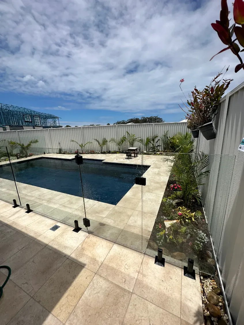 A Large Swimming Pool Is Surrounded By A White FeNCE — Mid Coast Glass Fencing In Forster, NSW