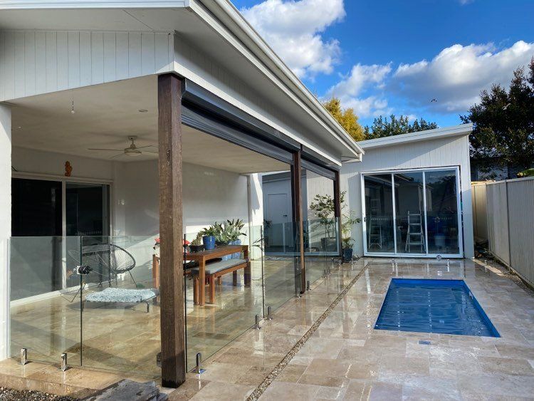 There is a swimming pool in the backyard of a house — Mid Coast Glass Fencing In Old Bar, NSW