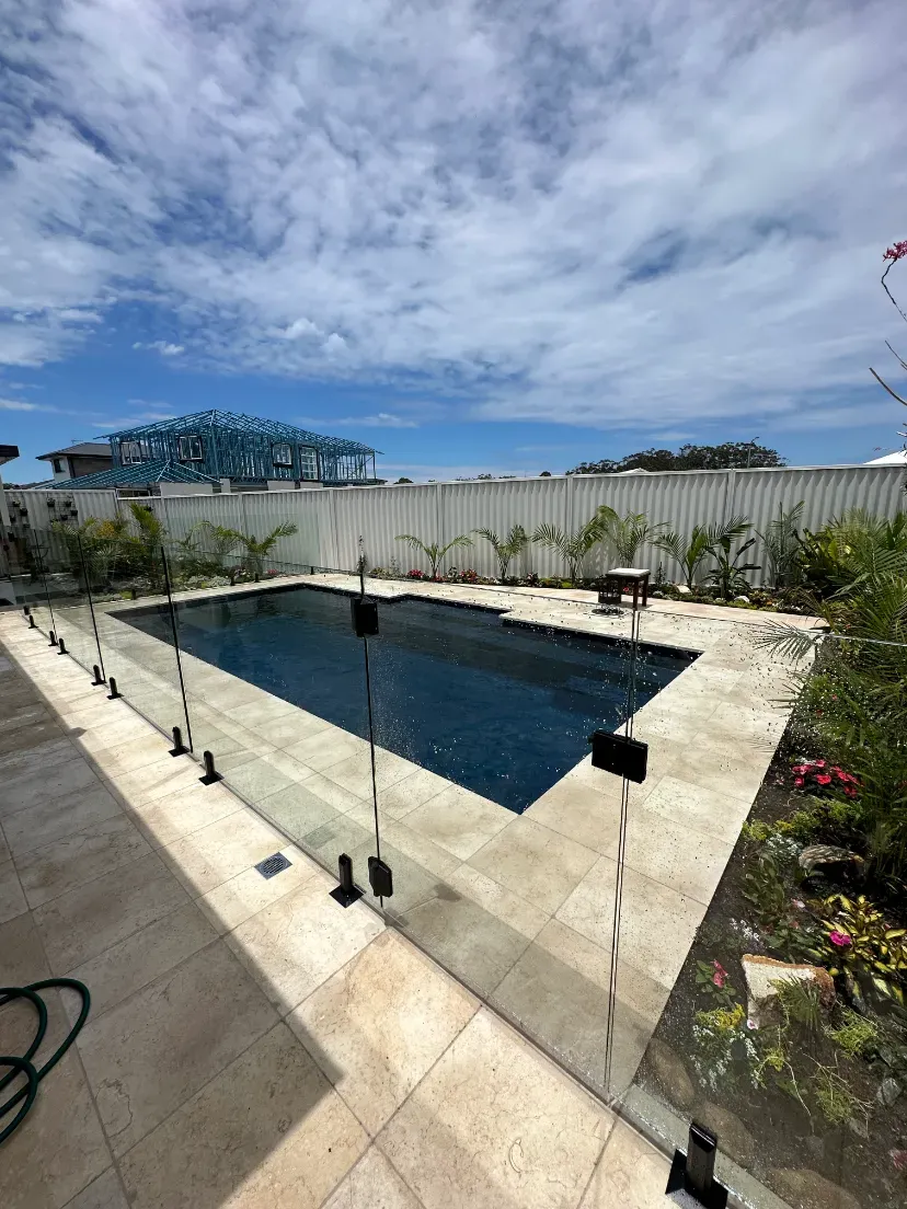 A large swimming pool surrounded by a glass fence in a backyard — Mid Coast Glass Fencing In Forster, NSW
