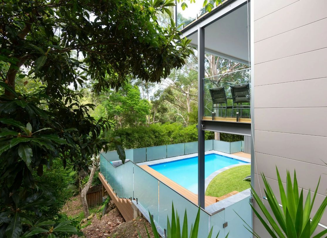 A house with a swimming pool in the backyard — Mid Coast Glass Fencing In Old Bar, NSW