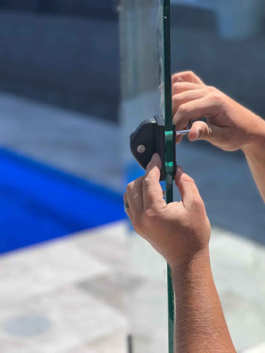 A person is holding a piece of glass in their hands — Mid Coast Glass Fencing In Hallidays Point, NSW