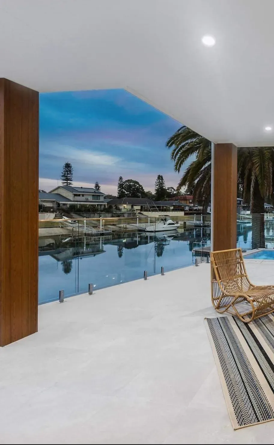 A patio with a view of a body of water and a swimming pool — Mid Coast Glass Fencing In Taree, NSW