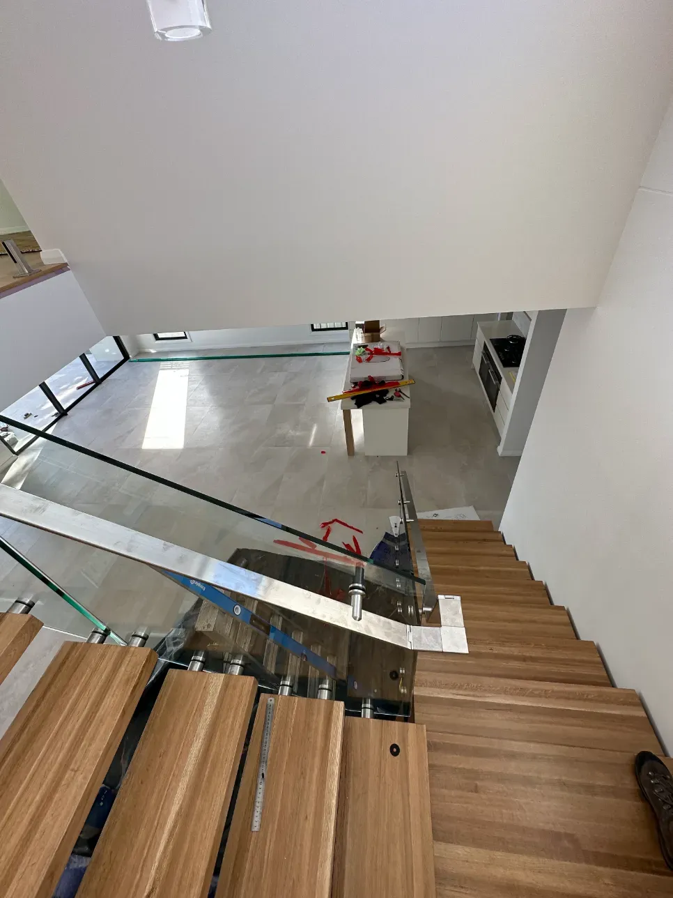 A Wooden Staircase With A Glass Railing In A HoUSE — Mid Coast Glass Fencing In Wauchope, NSW