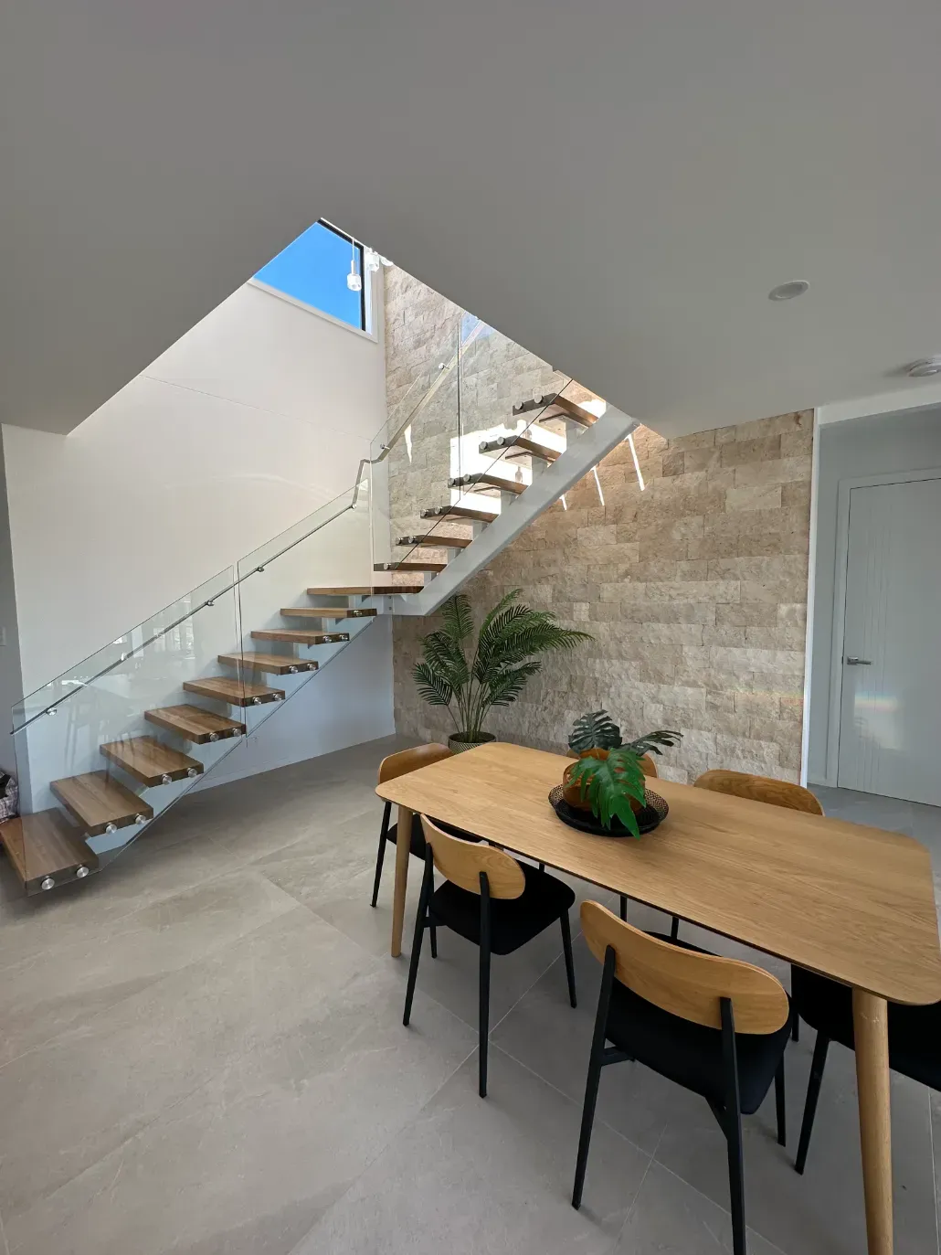 A Dining Room With A Table And Chairs And A StaircASE — Mid Coast Glass Fencing In Laurieton, NSW