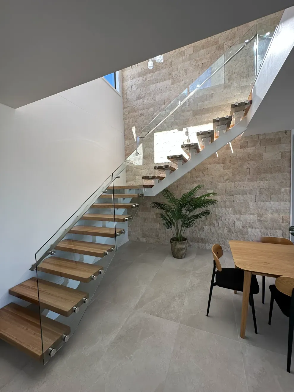A Staircase With Wooden Steps And A Glass Railing In A Dining ROOM — Mid Coast Glass Fencing In Forster, NSW