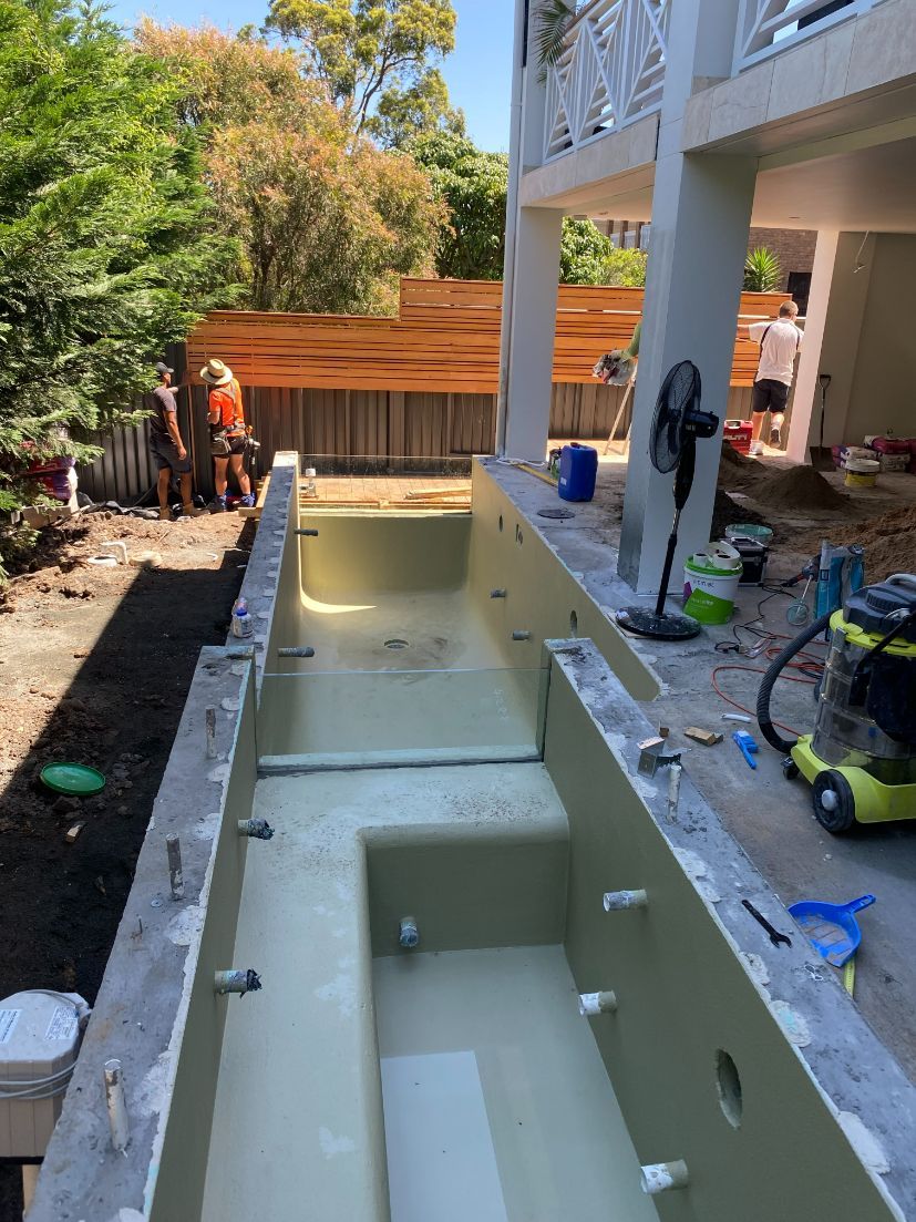 A Swimming Pool Is Being Built In The Backyard Of A House — Mid Coast Glass Fencing In Old Bar, NSW