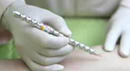 A person wearing gloves is writing on a person 's arm with a pen