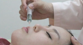 A woman is getting an injection in her eye.