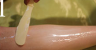 A person is waxing their arm with a spatula.