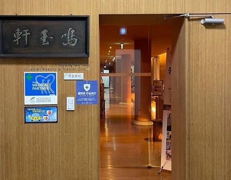 A wooden building with a glass door and a sign on the wall.