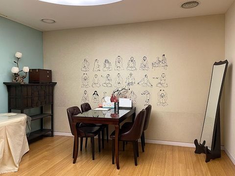 A dining room with a table and chairs and a mirror.