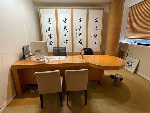 A room with a desk , chairs and a computer.