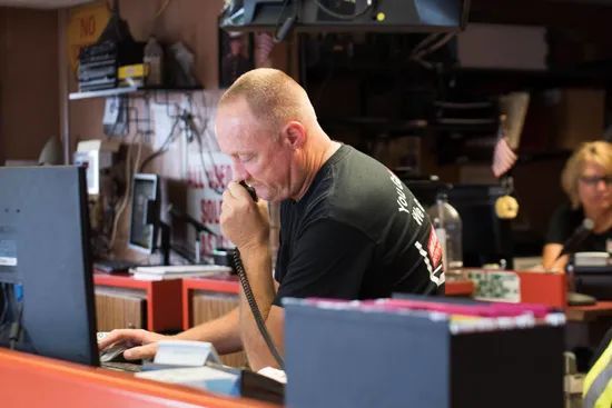 Man Holding Telephone While Using Computer — Cleves, OH — Miamitown Auto Parts & Recycling