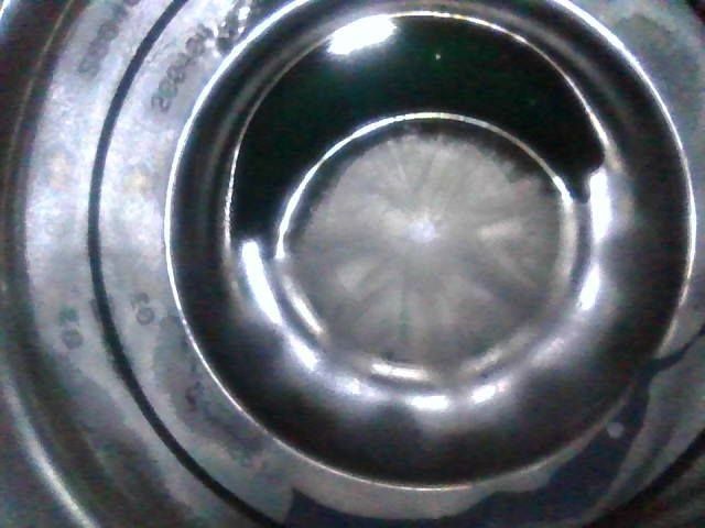 Close-up of a stainless steel bowl containing a frozen, starburst-like substance, likely ice.