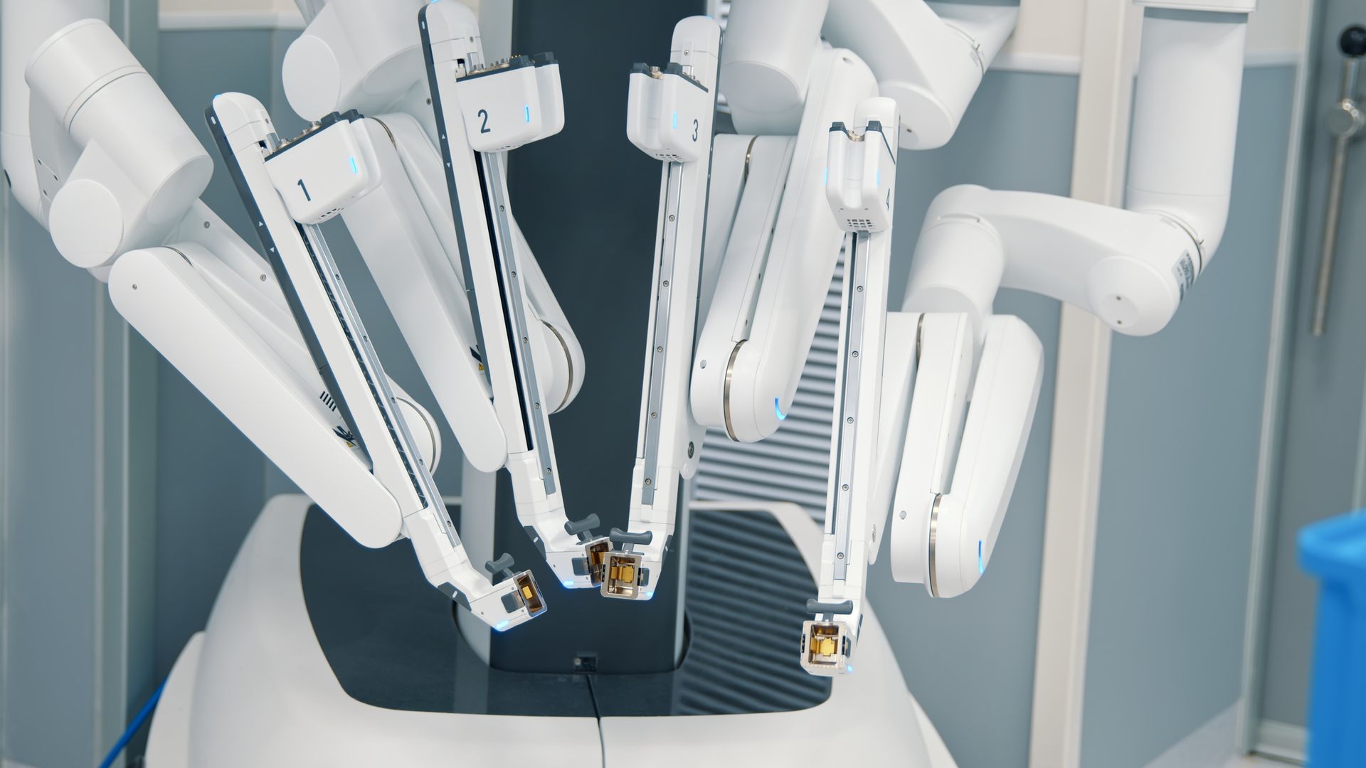 Two surgeons are looking up at a light in an operating room.