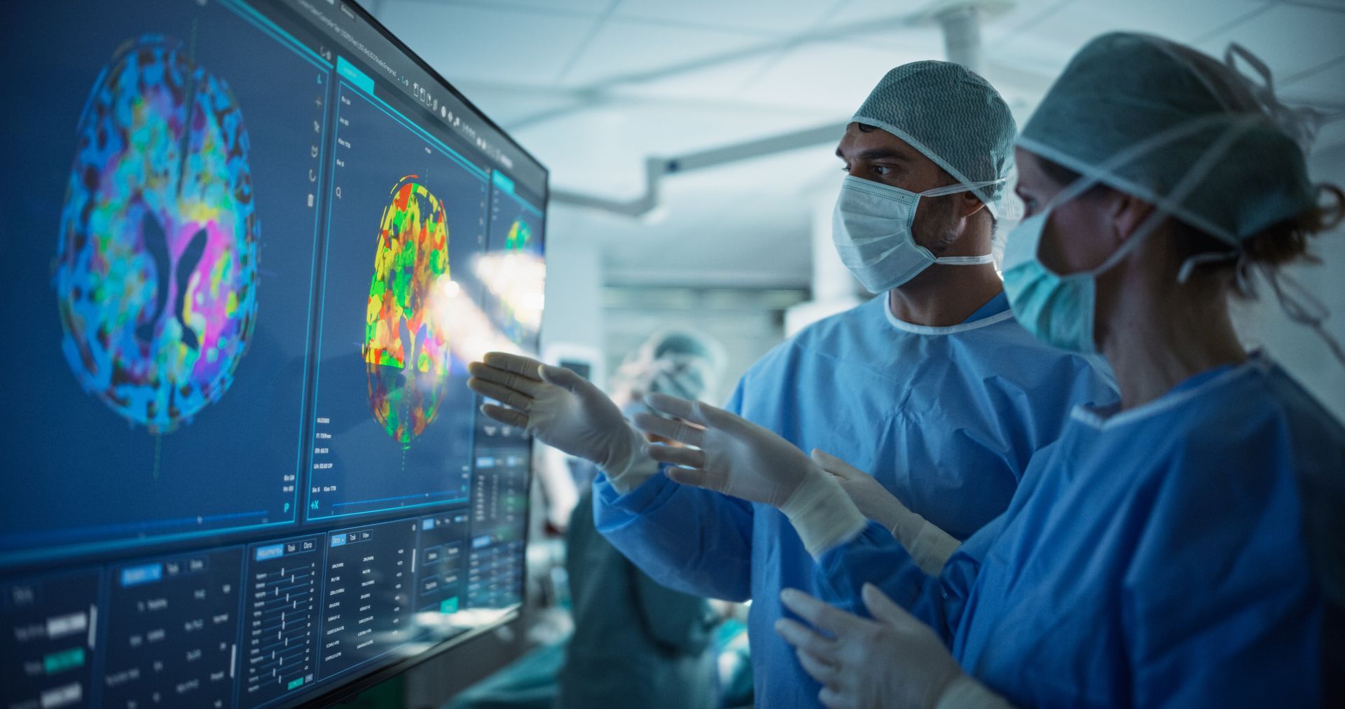 Two surgeons are looking up at a light in an operating room.