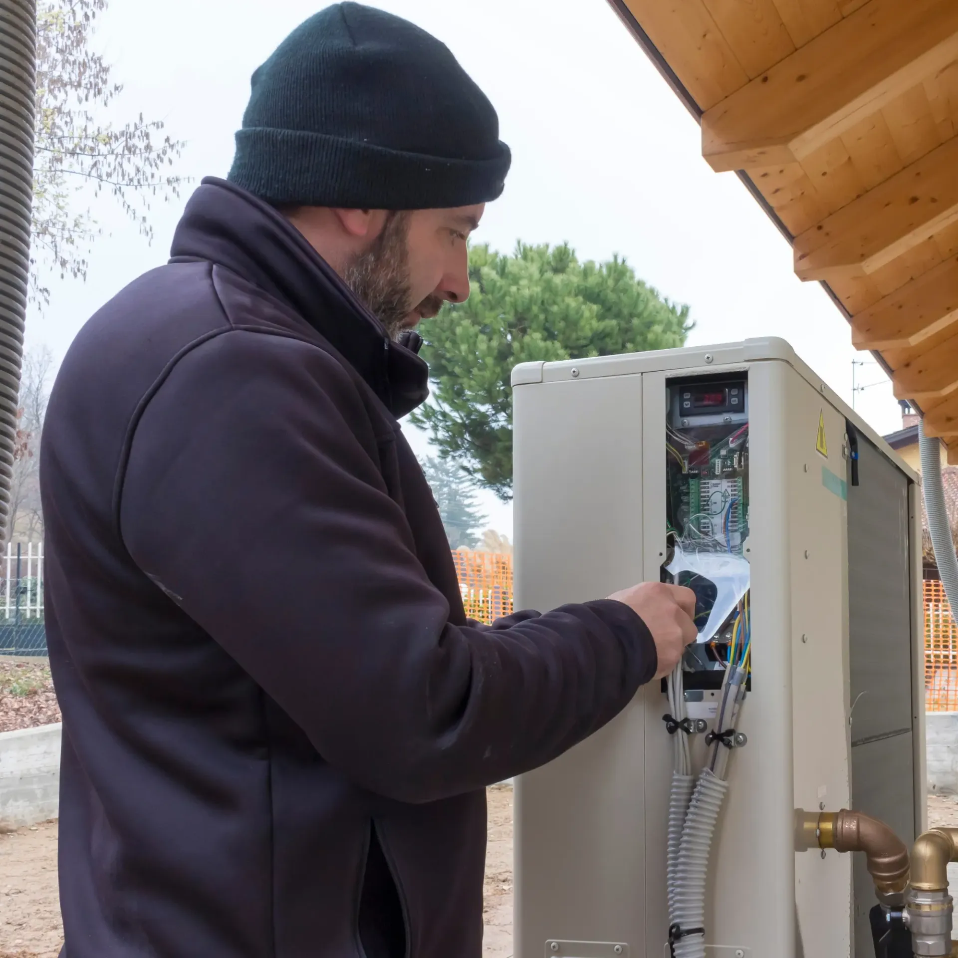 Air Fair Heat and Air LLC - A man wearing a black beanie is working on a machine