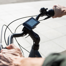 Een close-up van een persoon die op een fiets rijdt met een display op het stuur