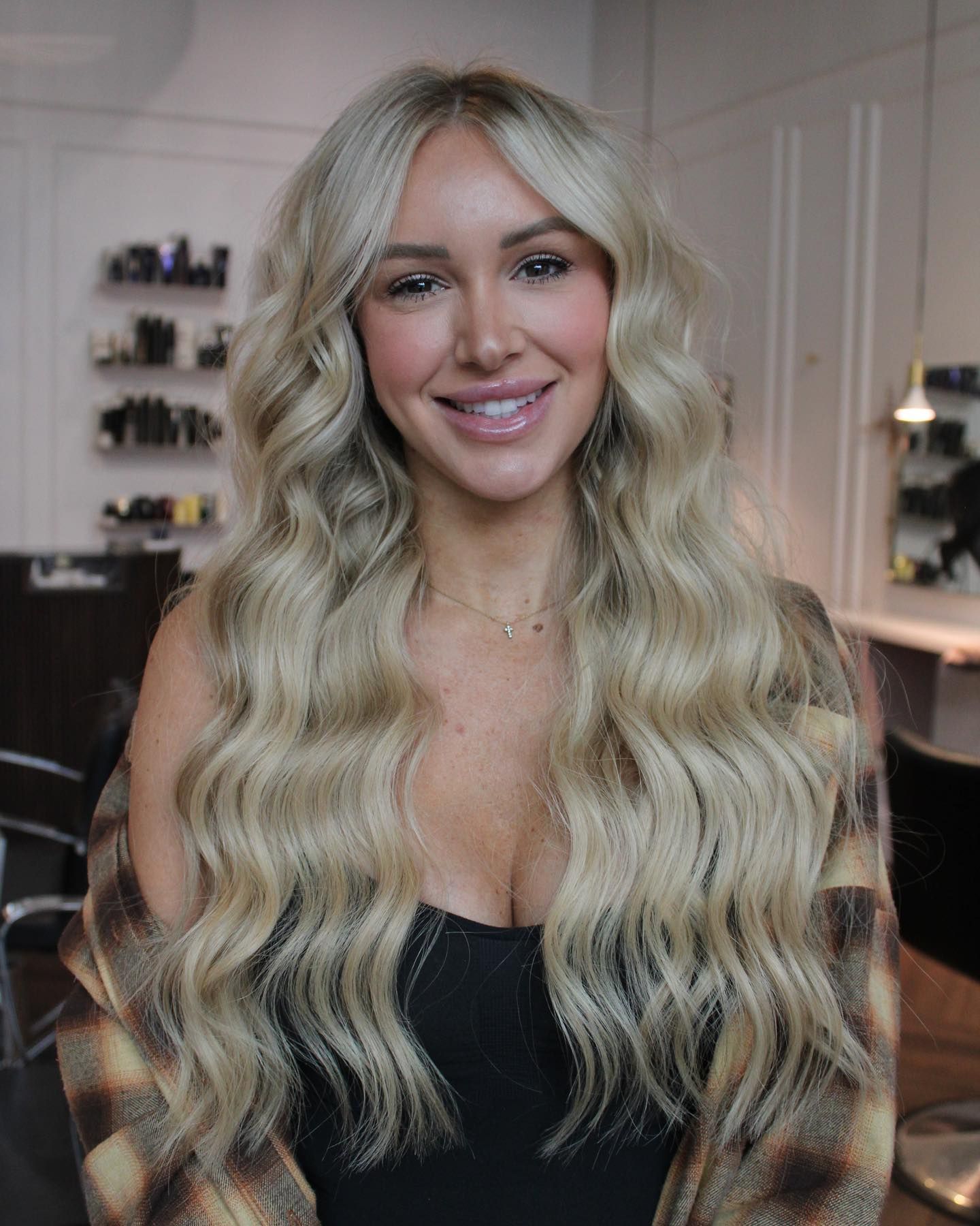 a woman with long blonde hair is smiling in a salon .