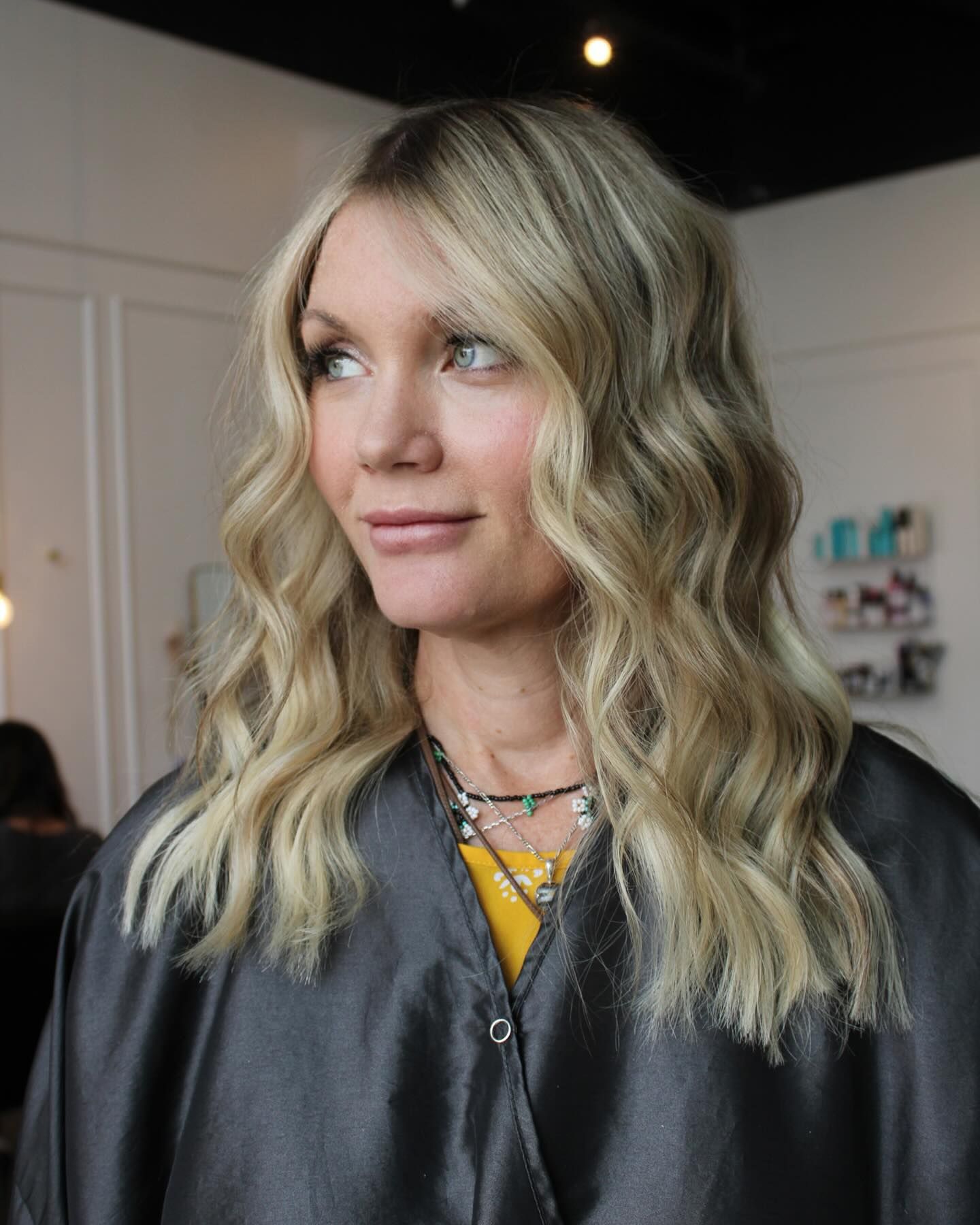 a woman with blonde hair is wearing a black cape .