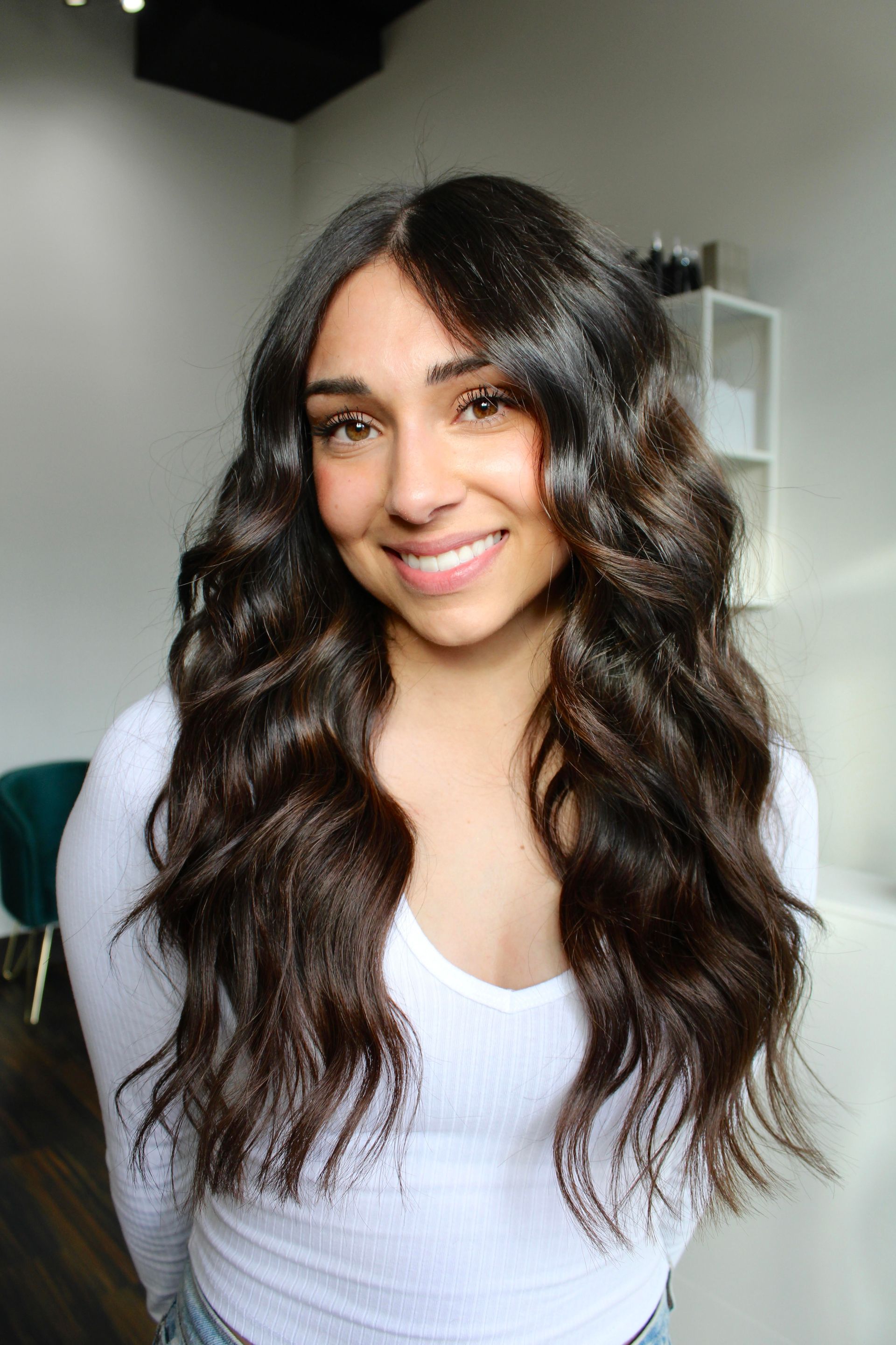 a woman is brushing another woman 's hair in front of a mirror .