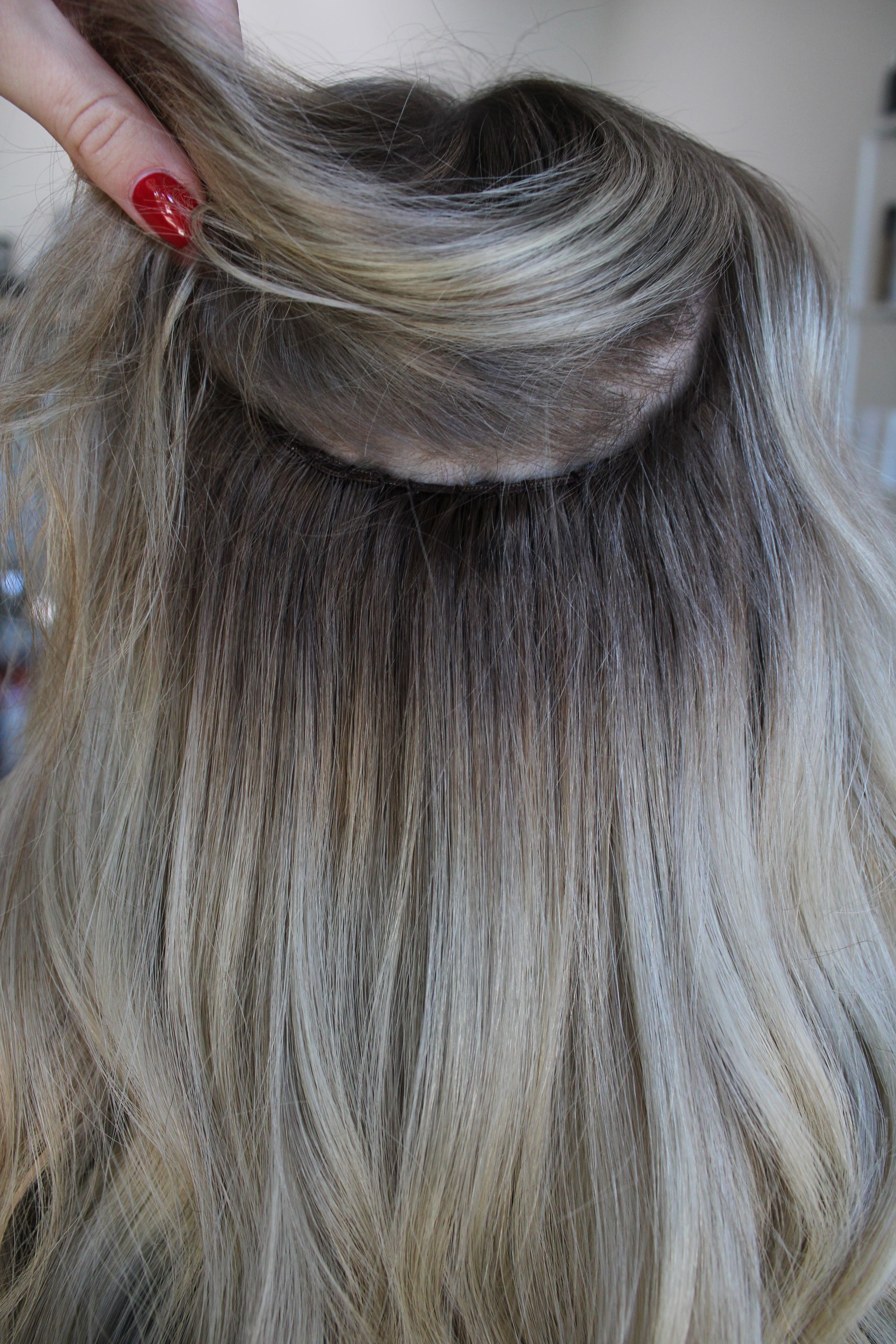 a woman is braiding her hair in a field .