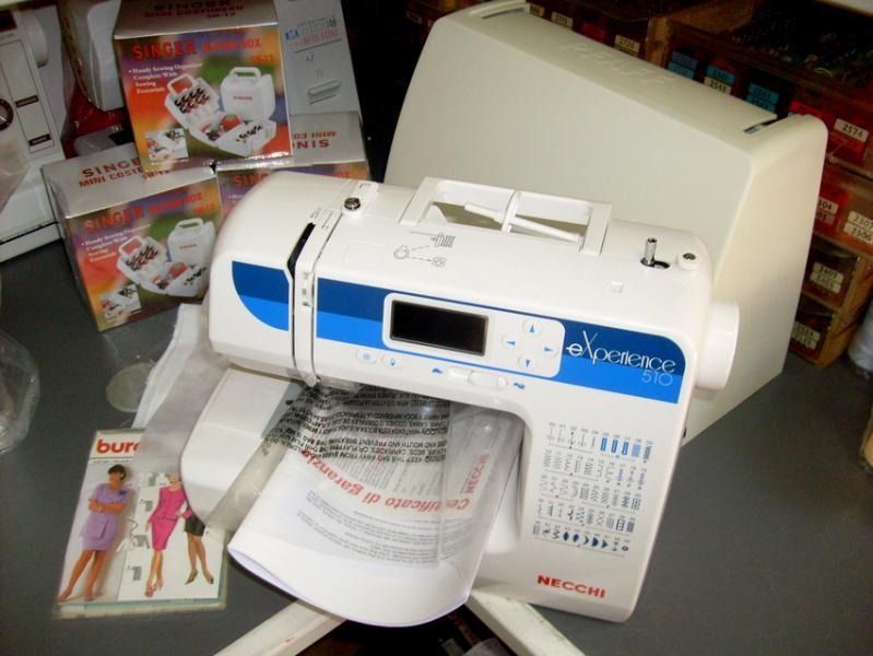 Macchina da cucire Necchi bianca e blu con accessori su un tavolo.