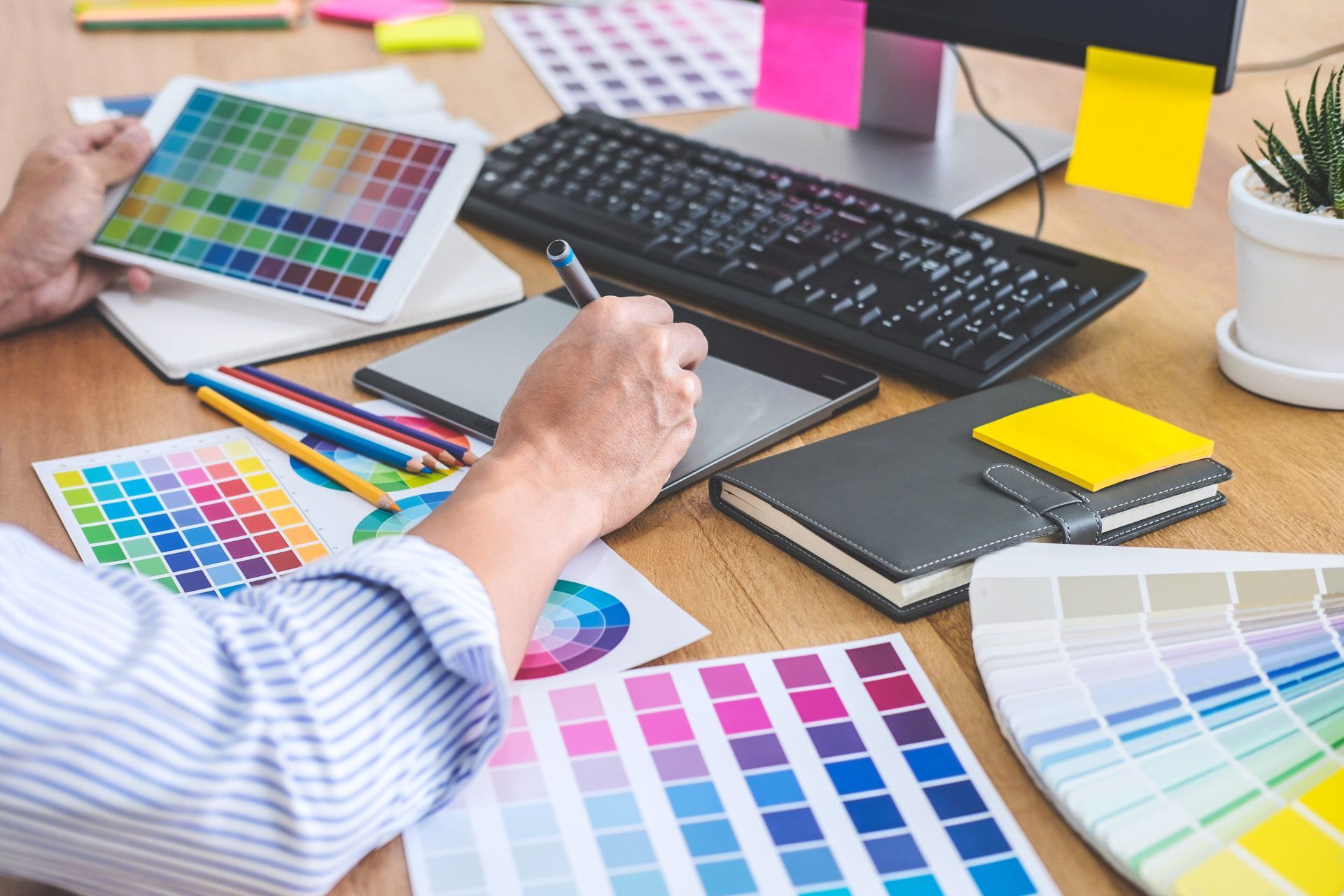 A Designer Works at A Desk with Color Palettes — On The Spot Signs Port Douglas In Port Douglas, QLD