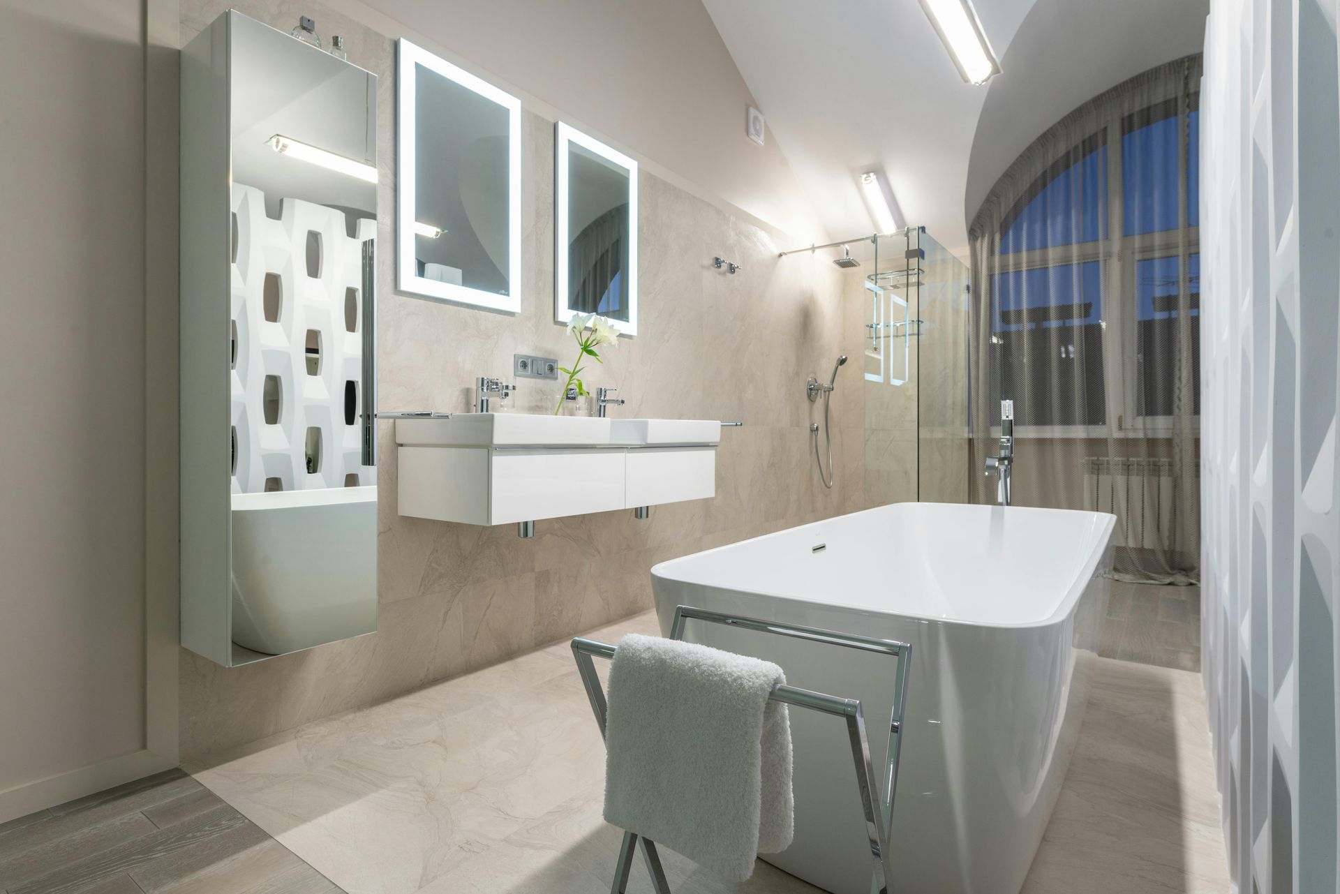 Modern white bathroom with a bathtub, two mirrors, and a glass shower.