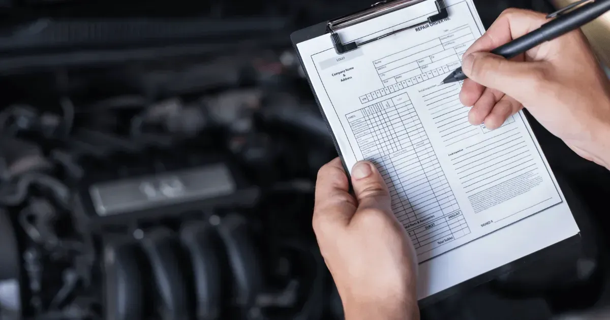 Technician filling out a vehicle inspection checklist for a pre-purchase.