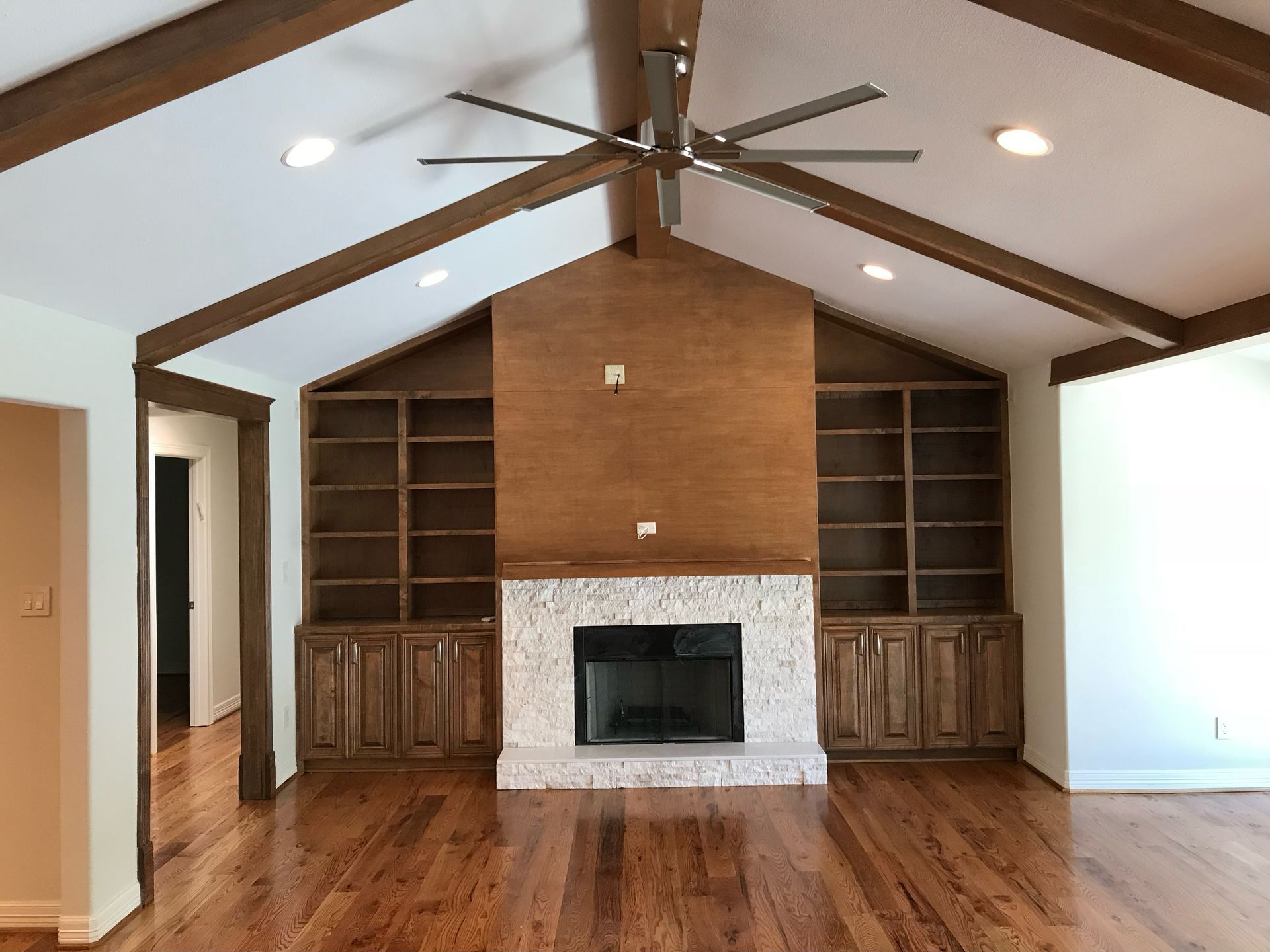 A living room with a fireplace and a ceiling fan