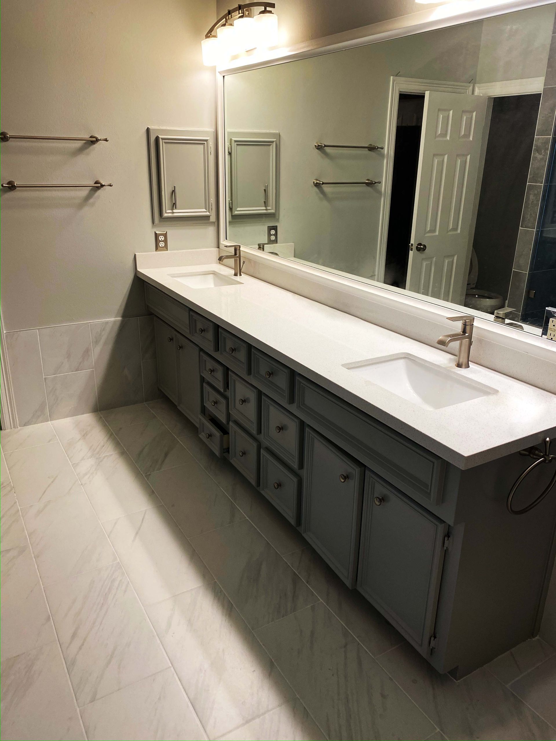A bathroom with two sinks and a large mirror.