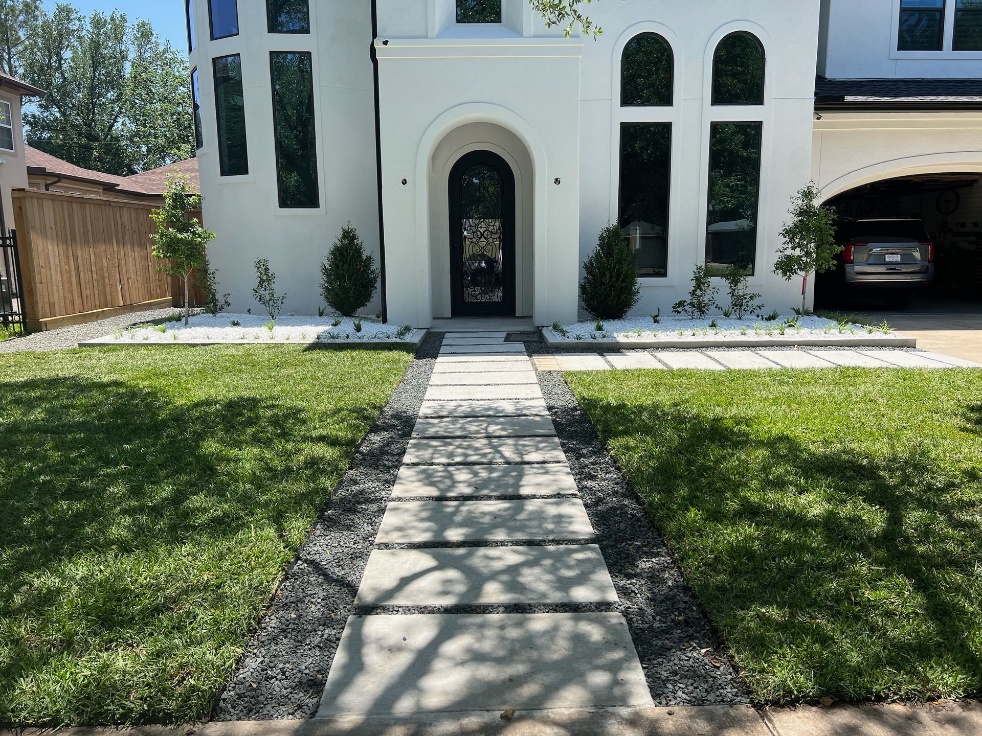 A white house with a concrete walkway leading to the front door.